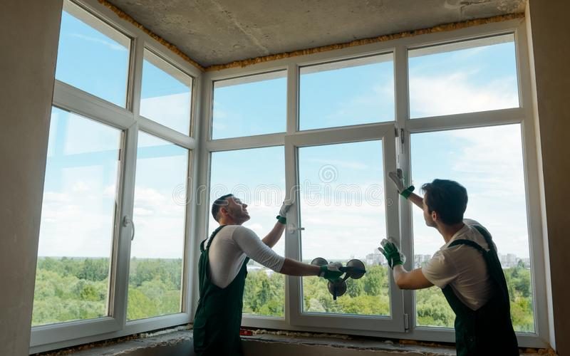 workers-installing-window-workers-installing-window-two-men-holding-mounting-sash-frame-using-133027169